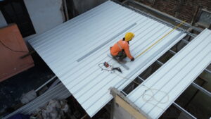 tukang sedang memasang atap UPVC
